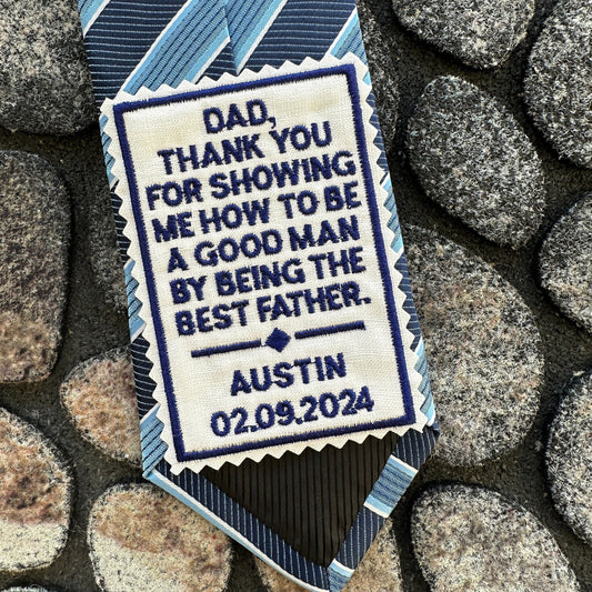 Personalized tie with embroidered message on a stone background