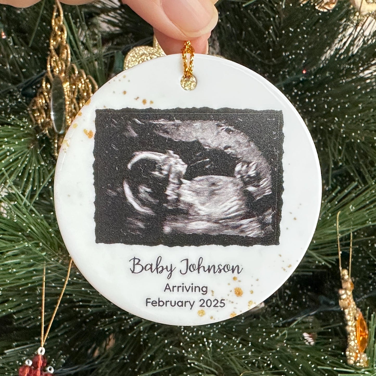 A round ceramic Christmas ornament featuring a baby ultrasound photo, personalized with the baby&#39;s family name and the year of birth, perfect for celebrating Christmasfor expecting parents and grandparents
